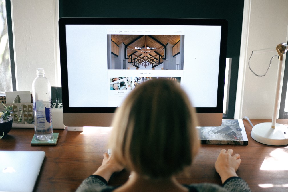 woman facing a computer, working on a website