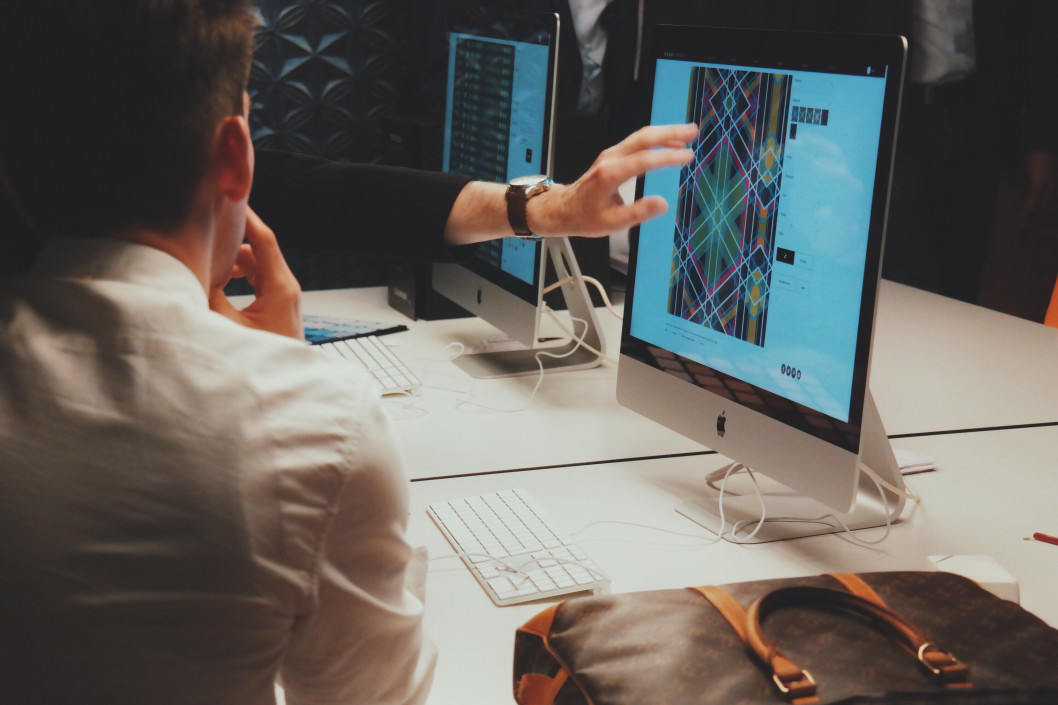 two people conversing over an image on the computer